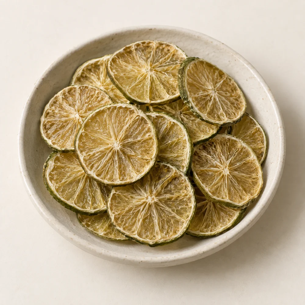 Rodajas deshidratadas de limón con cáscara verde oliva y pulpa translúcida; imagen ilustrativa